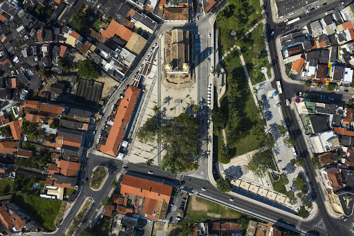 A imagem mostra a Praça do Senhor do Bonfim por cima de modo a identificar o projeto arquitetônico da reforma realizada no ano de 2019. É possível identificar a igreja de cima, a praça com pavimentação, árvores, além de casas e ruas em volta.