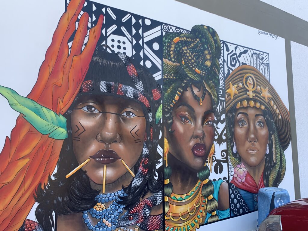 A ideia da artista é representar o empoderamento feminino e a diversidade. No mural é possível identificar a pintura de uma mulher indígena, uma negra e uma nordestina.
